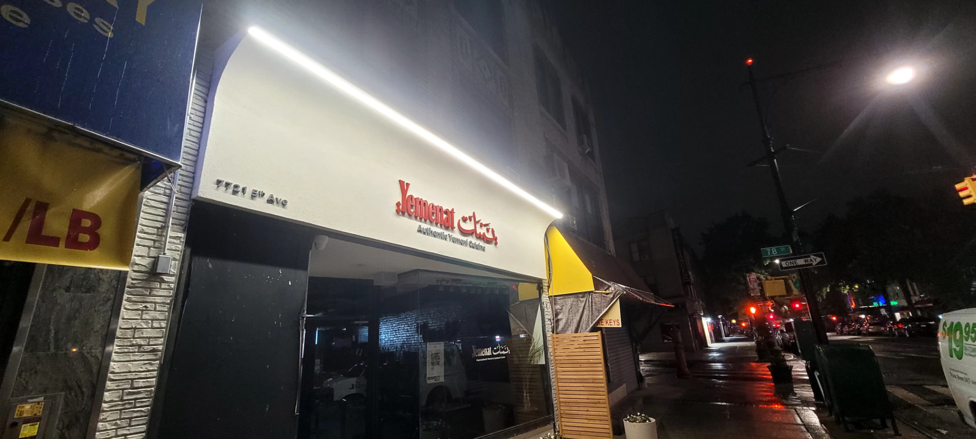 Finished restaurant storefront at night with red dimensional signage and an illuminated awning